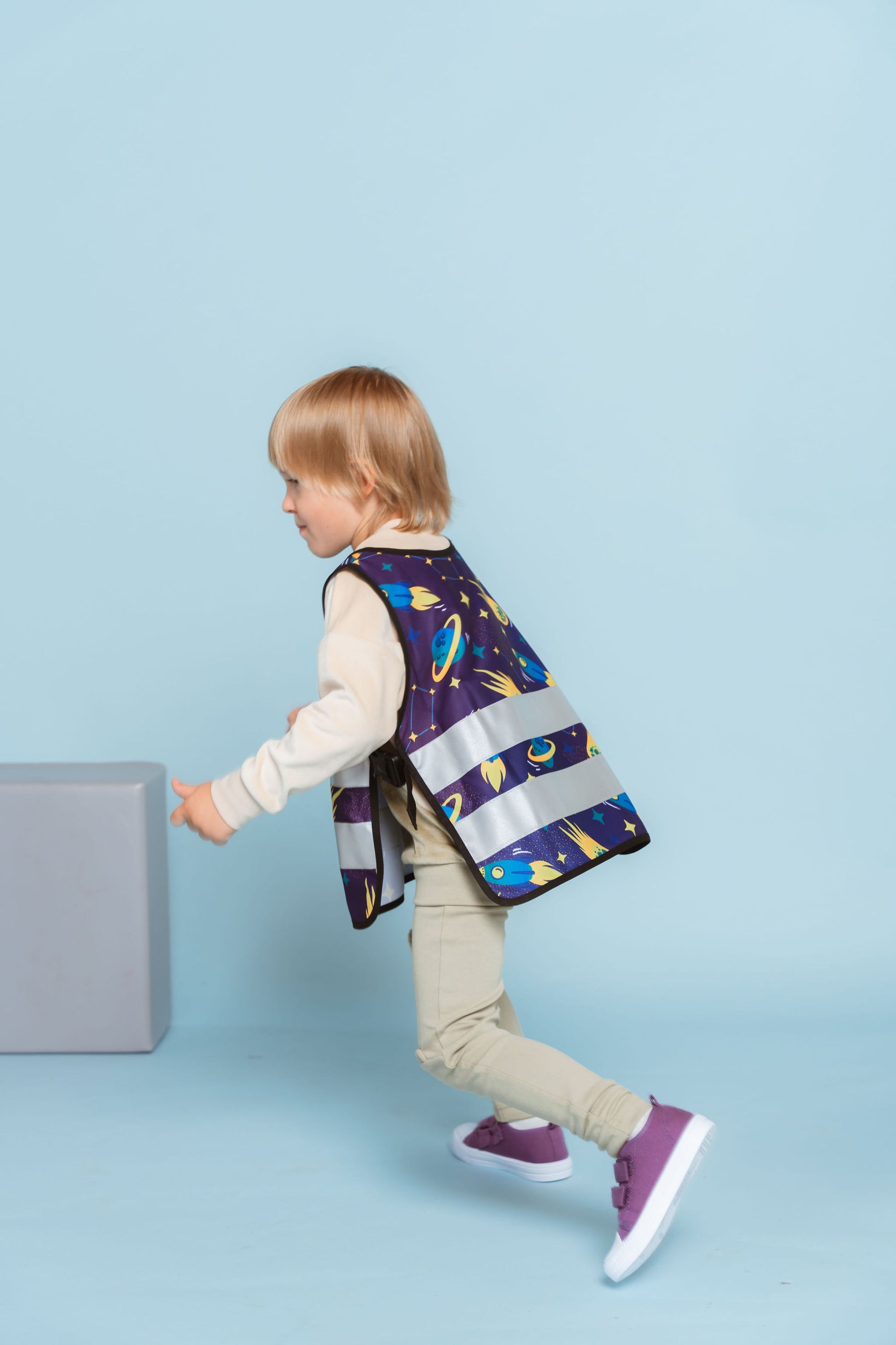 Boy wearing a reflective vest with space pattern. Custom reflective vest for kids