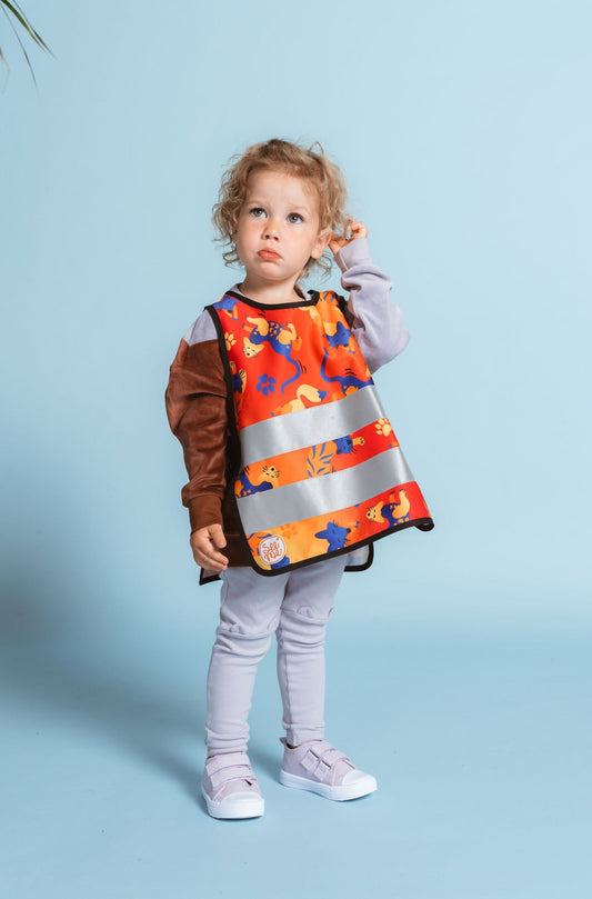 Little girl wearing orange reflective safety vest with foxes